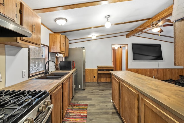 kitchen with wooden counters, dark wood-type flooring, stainless steel appliances, sink, and lofted ceiling with beams