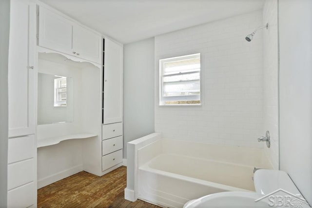 bathroom with tiled shower / bath and wood-type flooring