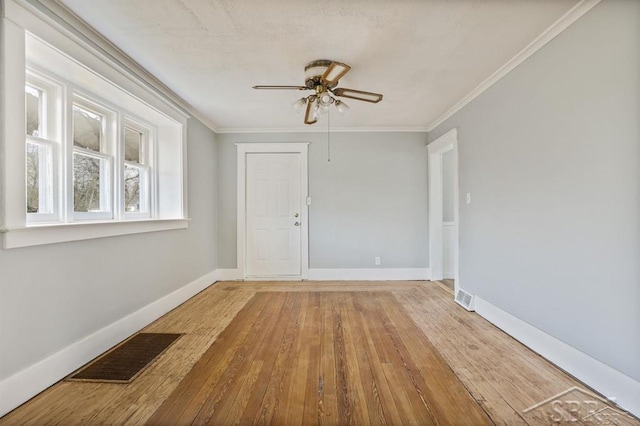 empty room featuring ceiling fan, wood-type flooring, and crown molding