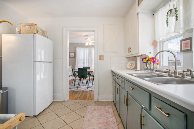 kitchen with ceiling fan, backsplash, white fridge, sink, and light tile patterned floors