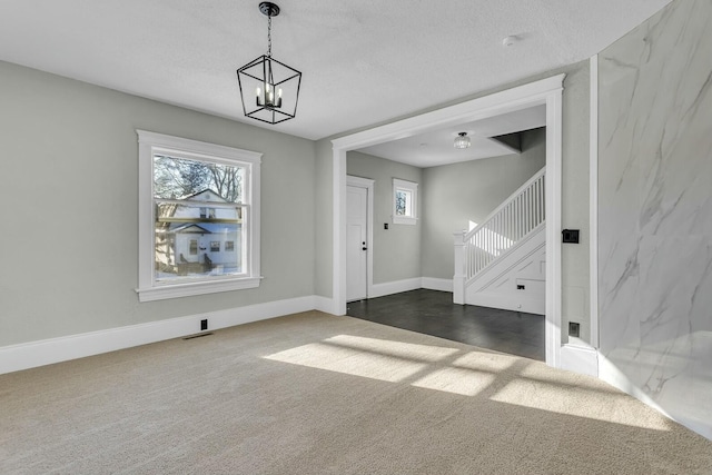 interior space with a notable chandelier and dark colored carpet