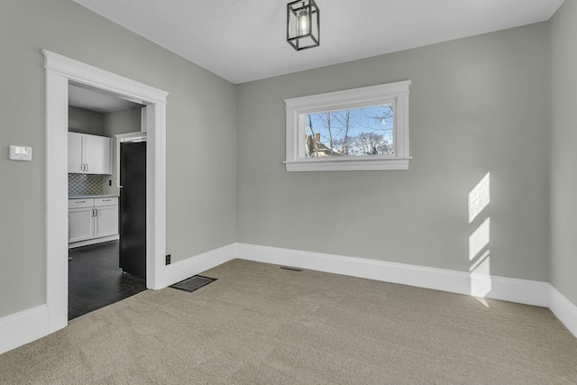 unfurnished dining area featuring dark carpet