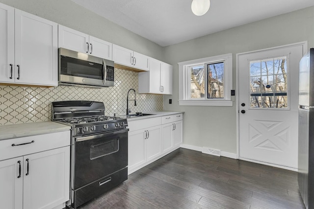 kitchen featuring backsplash, appliances with stainless steel finishes, sink, and white cabinetry