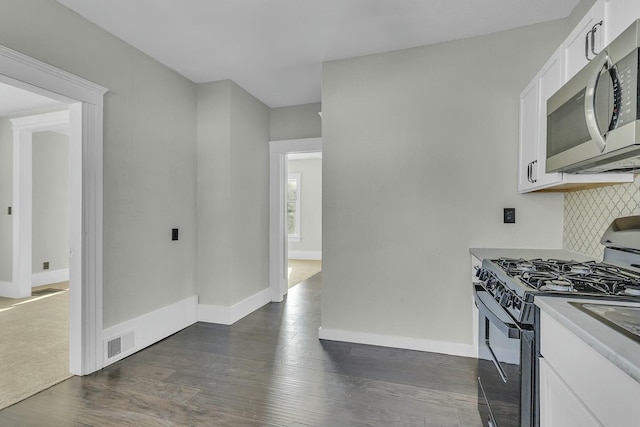 kitchen featuring white cabinetry, decorative backsplash, gas stove, and dark hardwood / wood-style floors