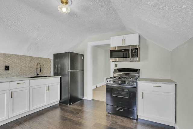 kitchen featuring lofted ceiling, black appliances, sink, dark wood-type flooring, and white cabinets