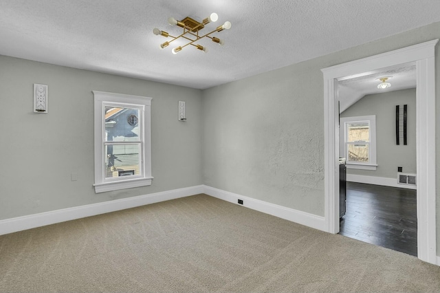 carpeted spare room featuring a textured ceiling