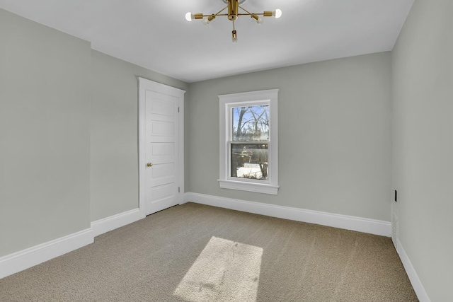 carpeted empty room with a chandelier