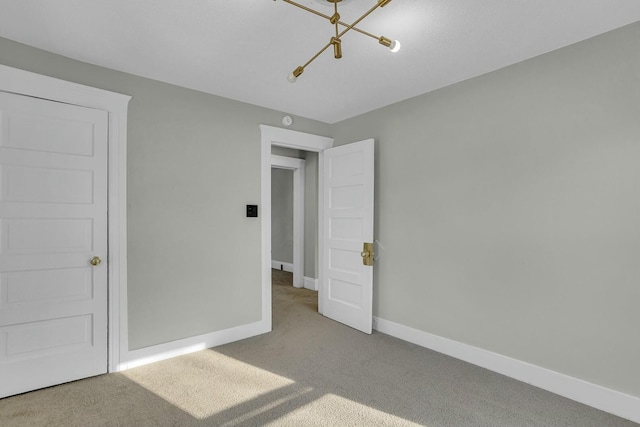 unfurnished bedroom featuring a chandelier and carpet flooring