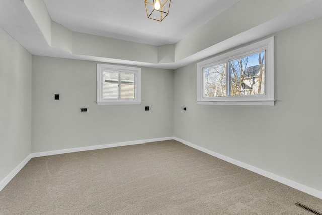 carpeted spare room with a tray ceiling