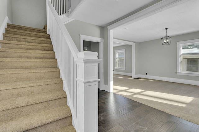 staircase featuring a chandelier and hardwood / wood-style flooring