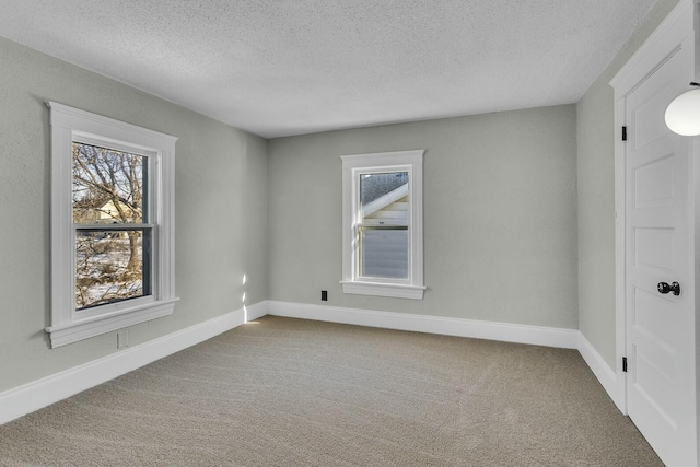 carpeted empty room featuring a textured ceiling