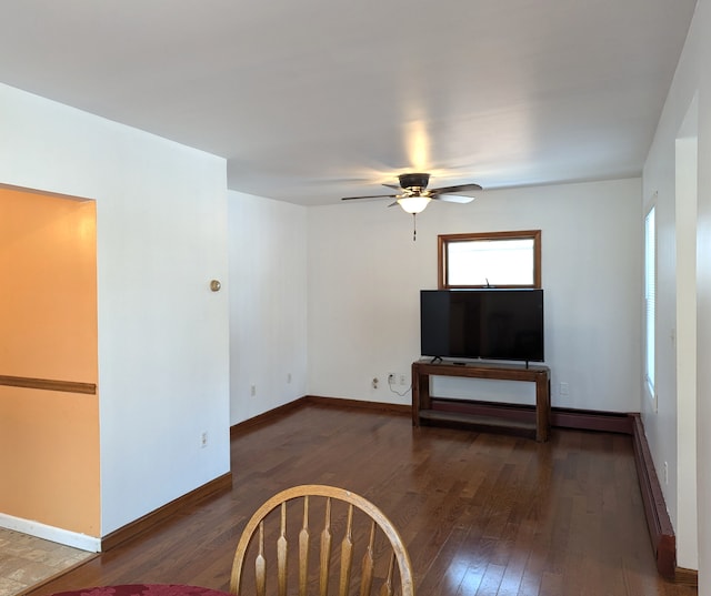 unfurnished living room with dark wood-type flooring and ceiling fan