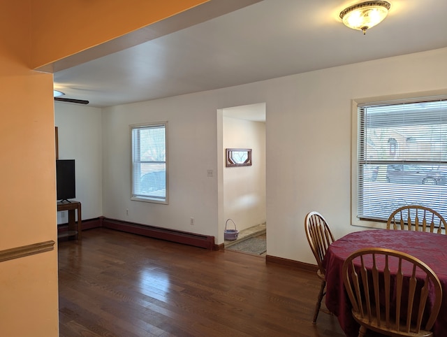 dining area with dark hardwood / wood-style flooring, ceiling fan, and baseboard heating