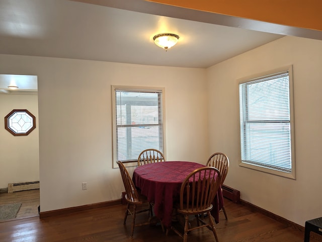 dining room with dark wood-type flooring and baseboard heating