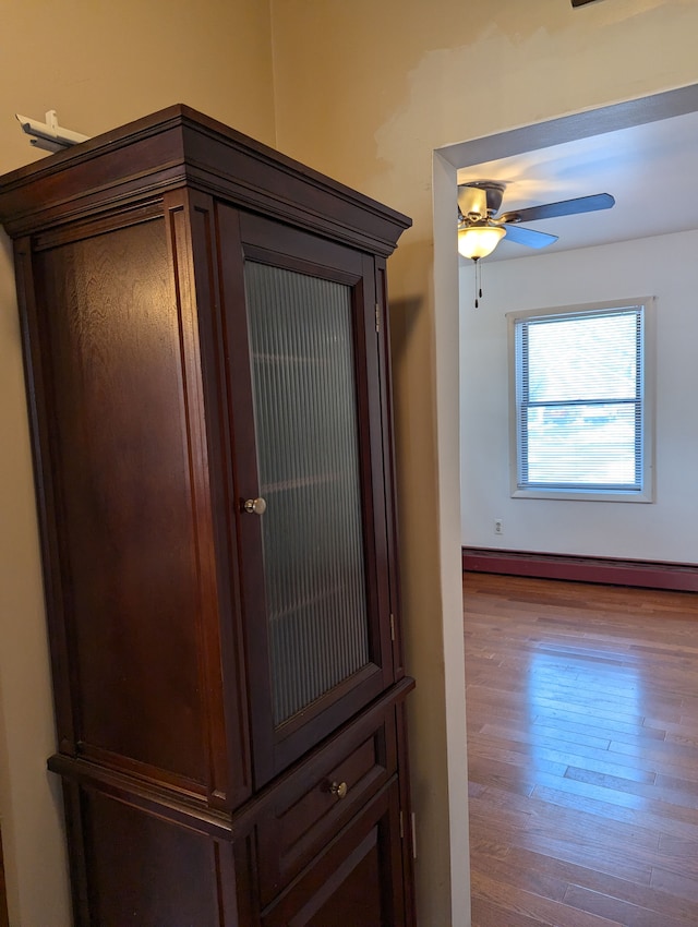 details featuring wood-type flooring, ceiling fan, and baseboard heating