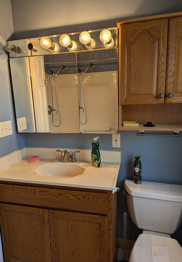 bathroom featuring vanity, toilet, and a shower