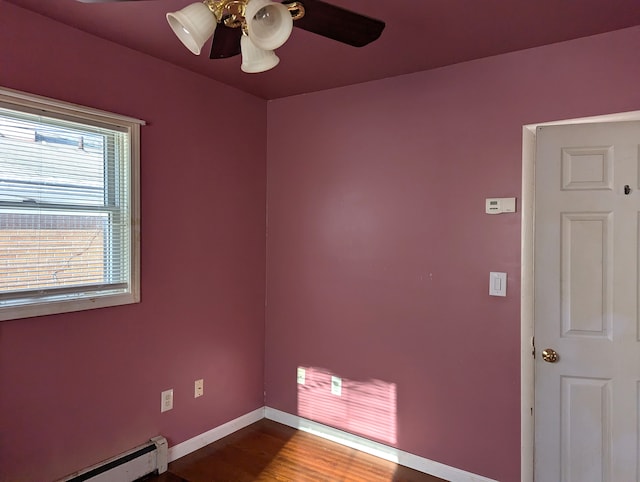 spare room featuring hardwood / wood-style floors, ceiling fan, and baseboard heating