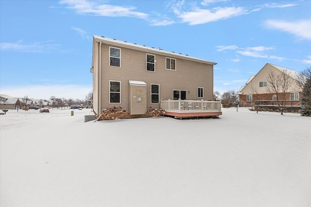 snow covered house featuring a deck