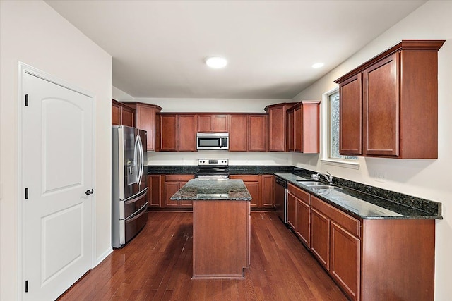 kitchen featuring dark stone countertops, a kitchen island, sink, stainless steel appliances, and dark hardwood / wood-style flooring