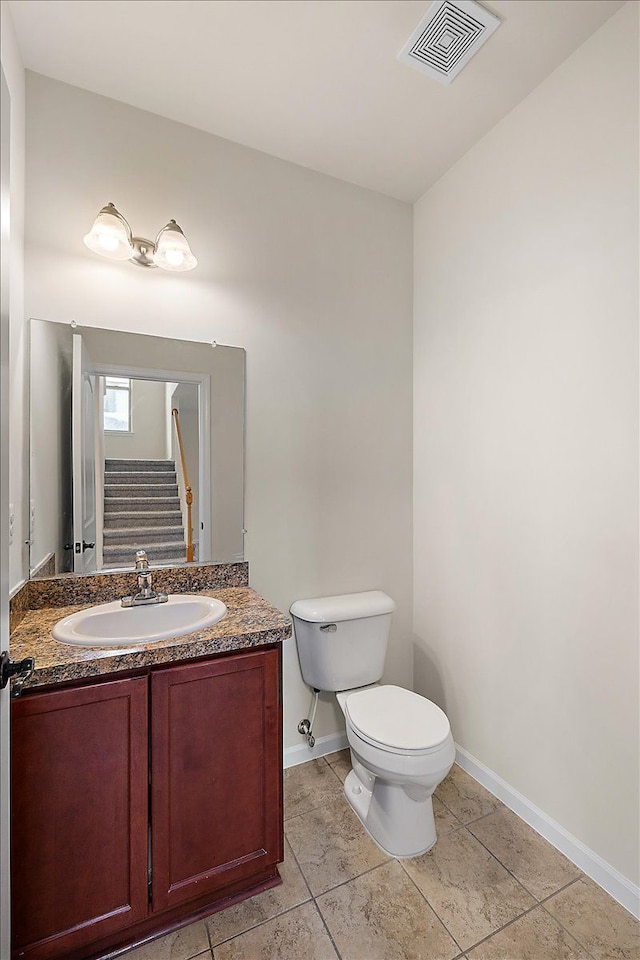 bathroom featuring toilet, vanity, and tile patterned flooring