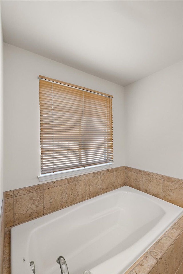 bathroom featuring tiled tub