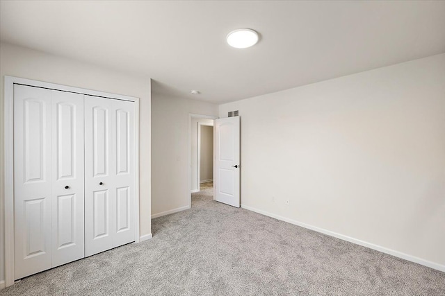 unfurnished bedroom with a closet and light carpet