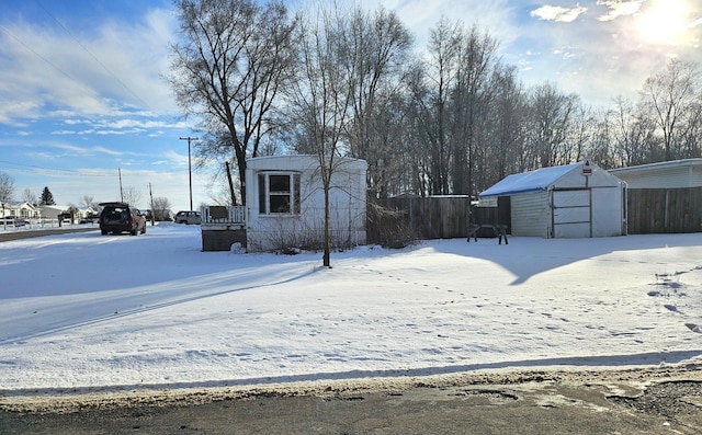 yard layered in snow with a shed