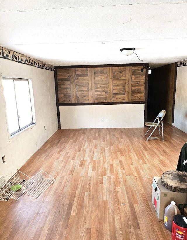 interior space featuring wood walls, a textured ceiling, and hardwood / wood-style flooring