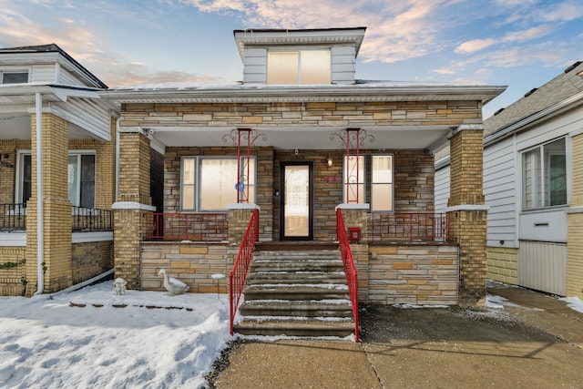 view of front of home with stone siding and covered porch