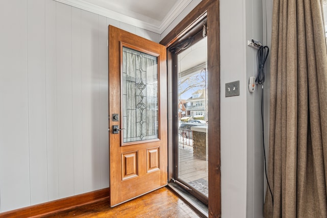 foyer featuring ornamental molding and wood finished floors