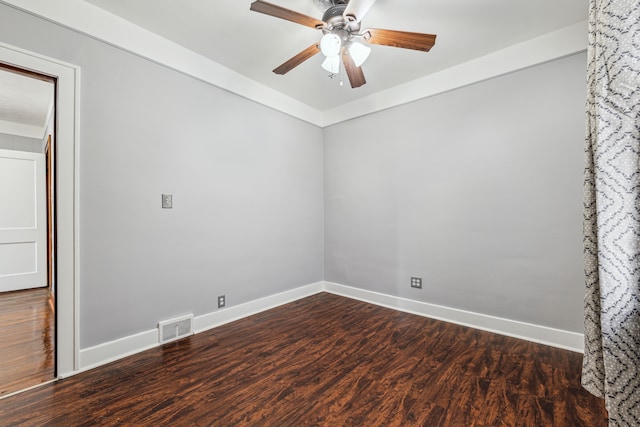 empty room with dark wood-type flooring, visible vents, ceiling fan, and baseboards