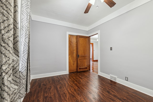 unfurnished room featuring baseboards, visible vents, ceiling fan, and dark wood-type flooring