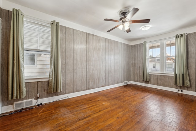 unfurnished room with baseboards, visible vents, and a ceiling fan