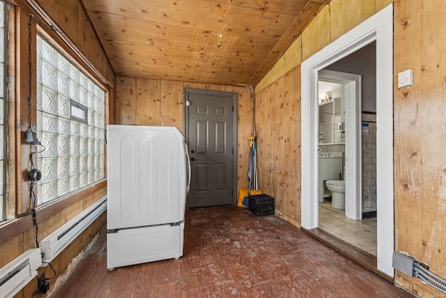 interior space featuring wood walls, wood ceiling, a baseboard heating unit, and wood finished floors