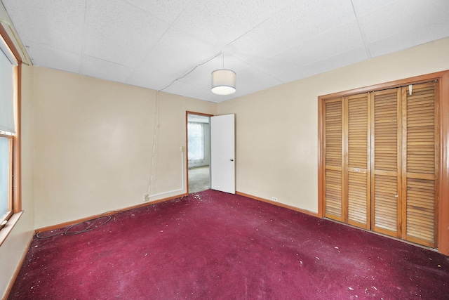 carpeted spare room featuring a paneled ceiling