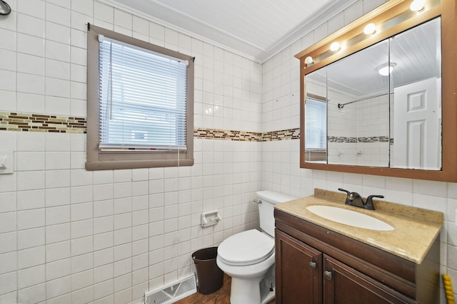 bathroom featuring vanity, a shower, tile walls, toilet, and crown molding