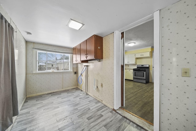 laundry room with cabinets and light hardwood / wood-style flooring