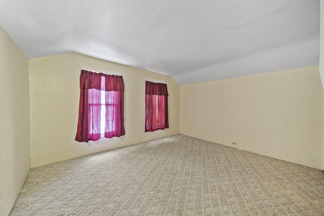 spare room featuring carpet and vaulted ceiling