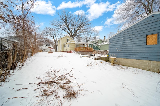 yard layered in snow featuring a wooden deck