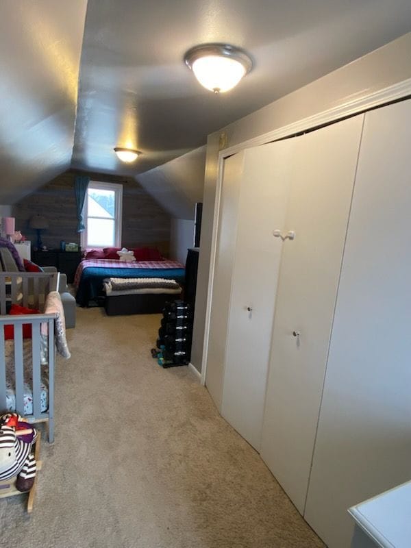 bedroom featuring vaulted ceiling and light colored carpet