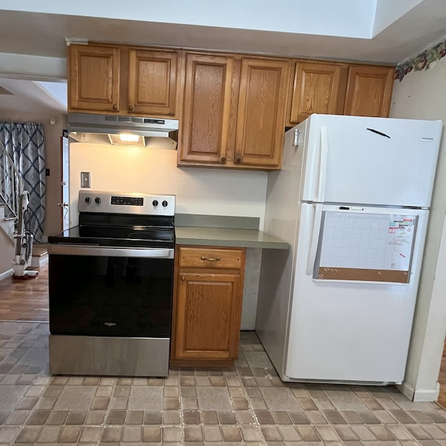 kitchen with electric stove and white fridge