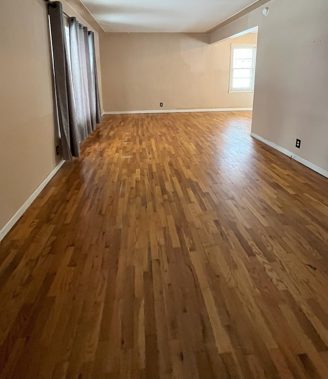 unfurnished room with dark wood-type flooring