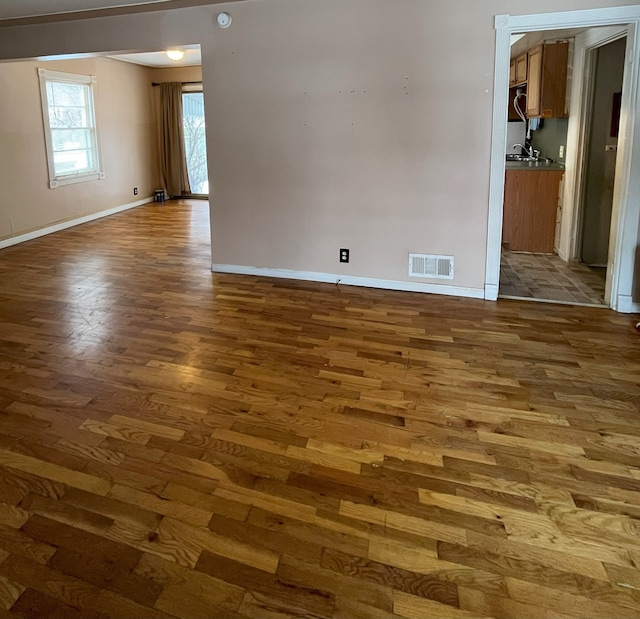 unfurnished room with dark hardwood / wood-style floors and sink