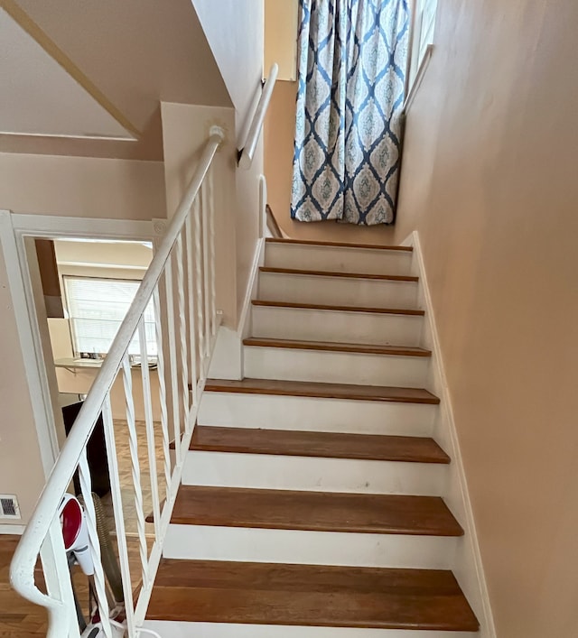 staircase with hardwood / wood-style floors