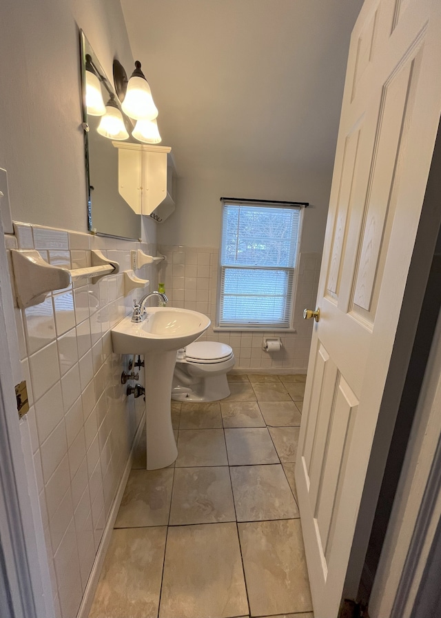 bathroom with tile walls, toilet, and tile patterned flooring