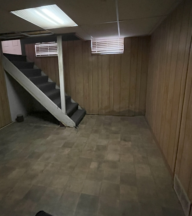 basement featuring wood walls