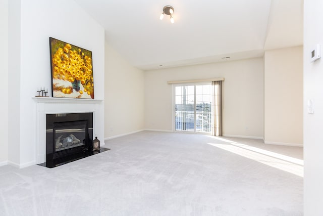 unfurnished living room with lofted ceiling and light carpet