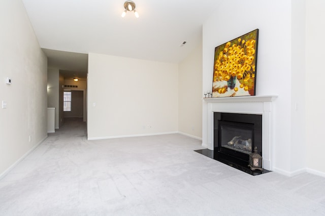 unfurnished living room with vaulted ceiling and light colored carpet