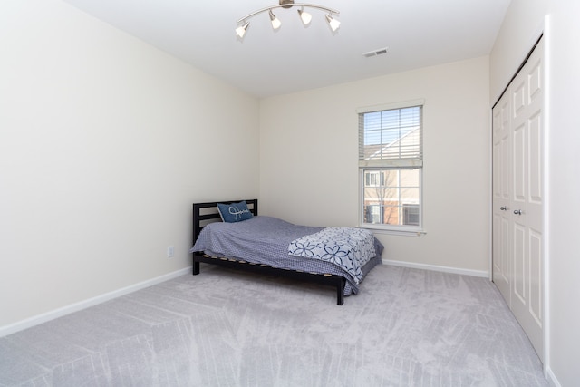 bedroom with light carpet and a closet