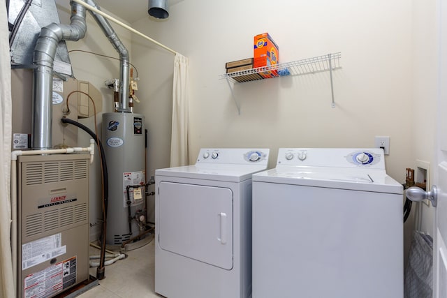 laundry area with washing machine and clothes dryer and gas water heater